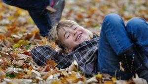 wohin-mit-dem-herbstlichen-Laub_ Kind im Laub